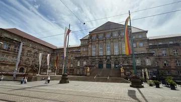 Historisches Gebäude mit Fahnen und Treppen.