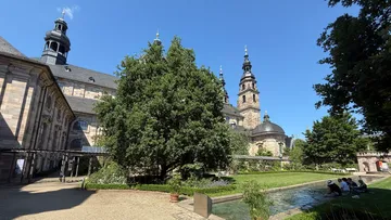 Historische Kirche neben einem Gartenteich.