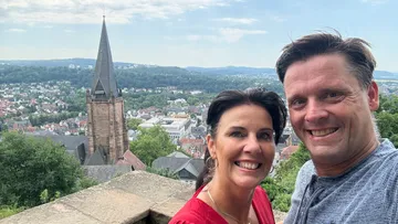 Paar lächelt mit Stadtblick.