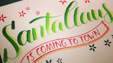 Calligraphy reads 'Santa Claus Is Coming to Town'.