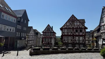Fachwerkhäuser an einer Kopfsteinpflasterstraße.