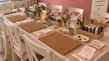 Kunstbedarf auf dekoriertem Tisch angeordnet.