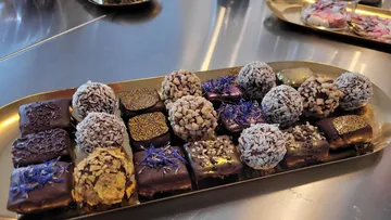 Verschiedene Pralinen auf einem goldenen Tablett.