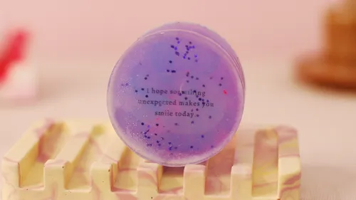 Purple soap with inspirational text on holder.