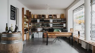 Weinladen mit Flaschen und Holzfässern.
