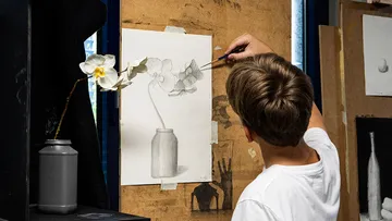 Kind zeichnet Blumen im Kunststudio.
