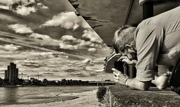 Person fotografiert Fluss-Stadtansicht vom Balkon.