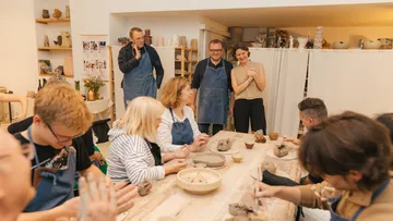 People sculpting clay in a pottery class.