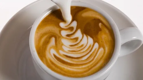 Cup of coffee with milk swirling design.