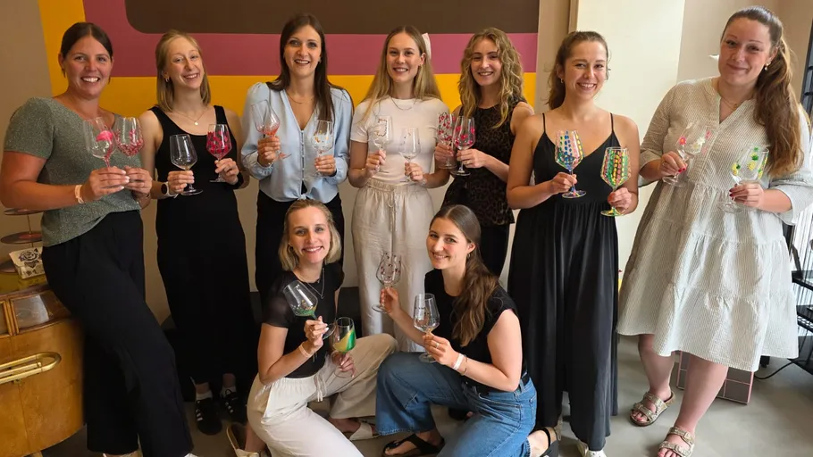 Frauen halten personalisierte Weingläser drinnen.