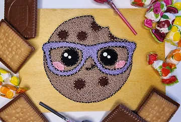 Kunstwerk eines Kekses mit Brille, umgeben von Süßigkeiten.