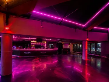 Leere Nachtclub-Bar mit pinken Neonlichtern.