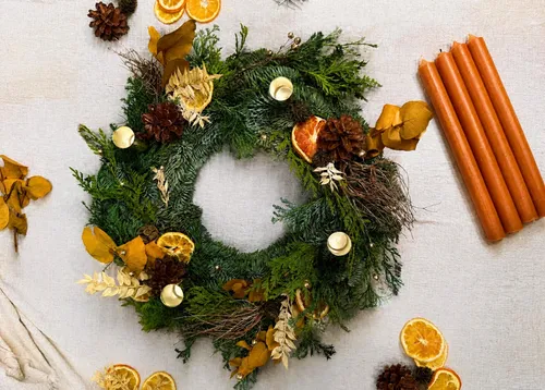 Weihnachtskranz mit Kerzen und Tannenzapfen.