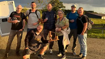 Group of seven people posing outdoors.