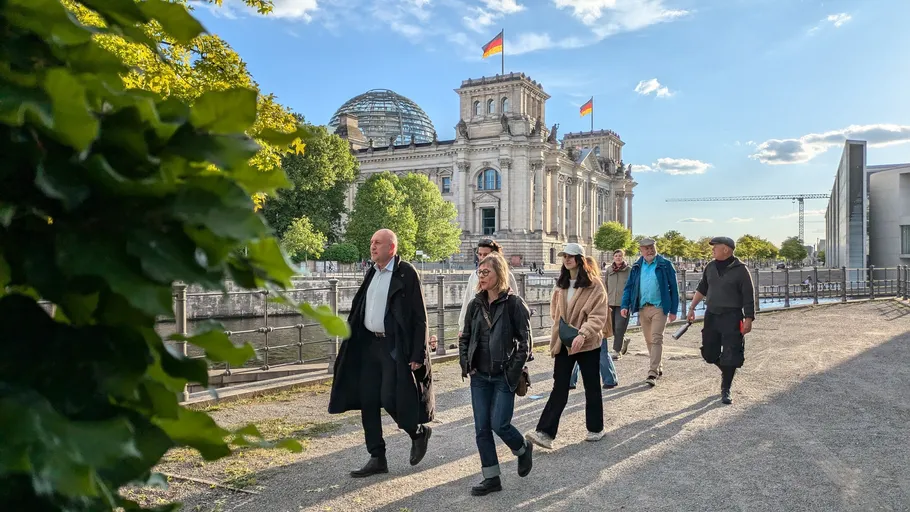Menschen laufen in der Nähe des Reichstagsgebäudes.
