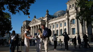 Touristen versammeln sich vor historischem Regierungsgebäude.
