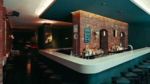 Brick bar with bottles, dimly lit room.