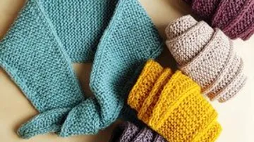 Colorful knitted scarves arranged on a table.