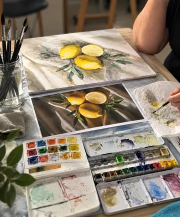 Künstler malt Zitronen mit Aquarellfarben.