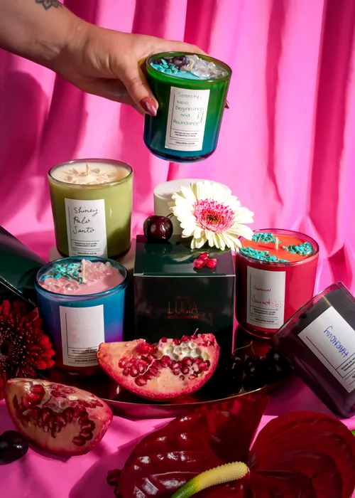 Bunte Kerzen mit Blumen und Früchten arrangiert.