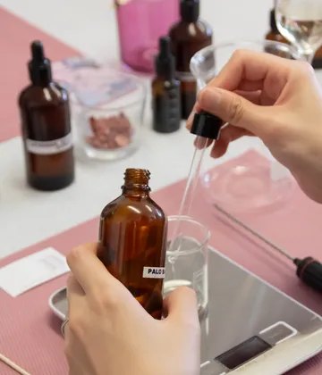 Hands mix ingredients using glass dropper.