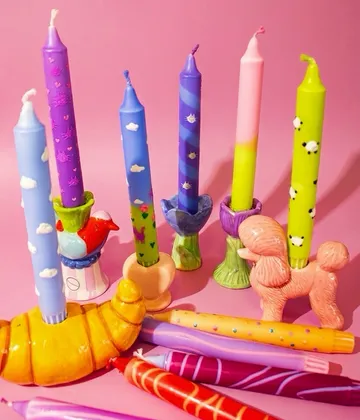 Colorful candles on pink background.