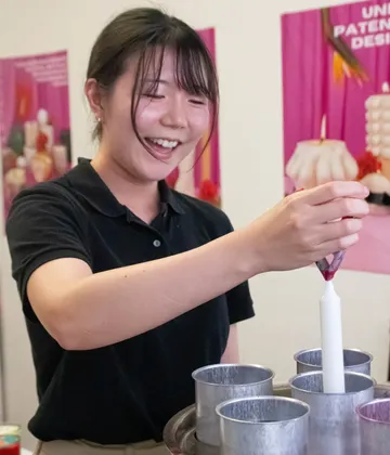 Woman making candles in a workshop.