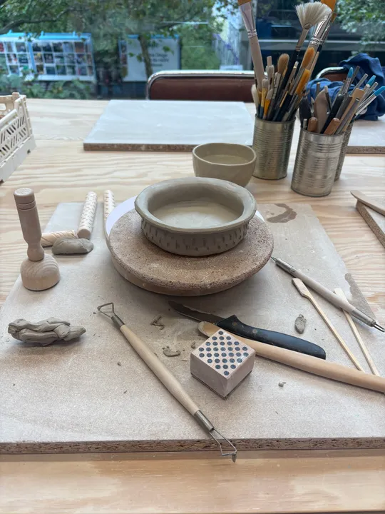 Pottery tools arranged on wooden table.