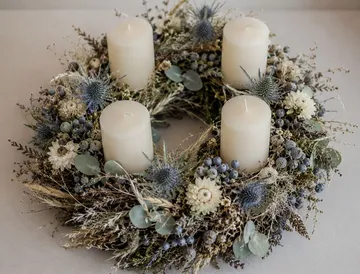 Four candles on a floral wreath centerpiece.