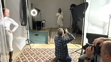 Photographers capture a model in a studio.