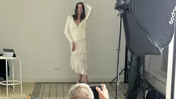 Model poses indoors for professional photographer.