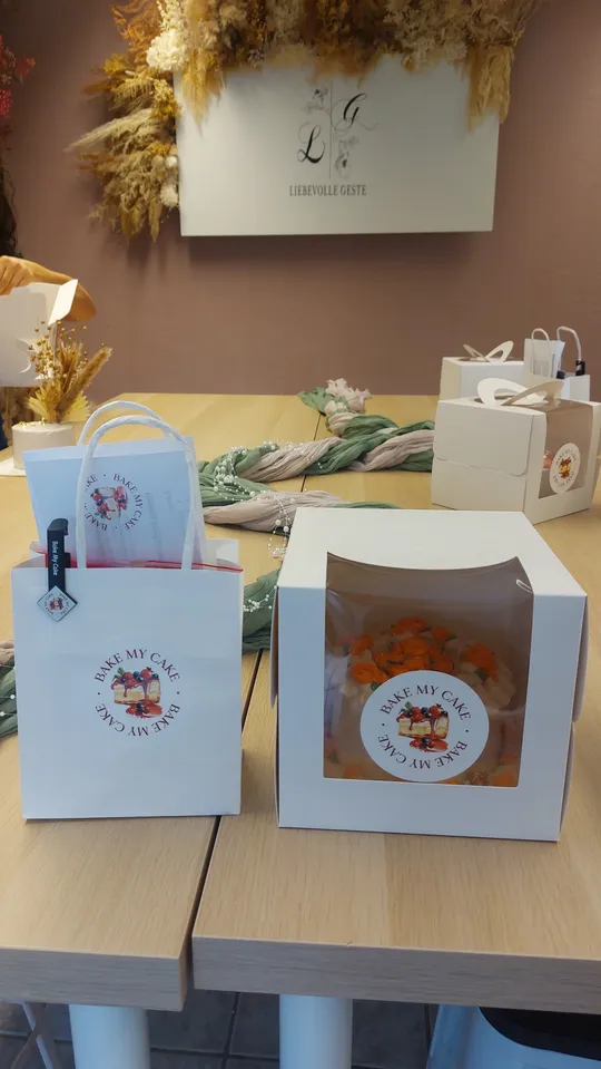 Kuchenbox und Tüte auf Holztisch.