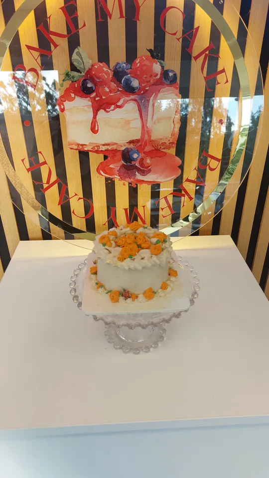 Kuchen mit Blumen auf Glasständer, Bäckerei-Hintergrund.