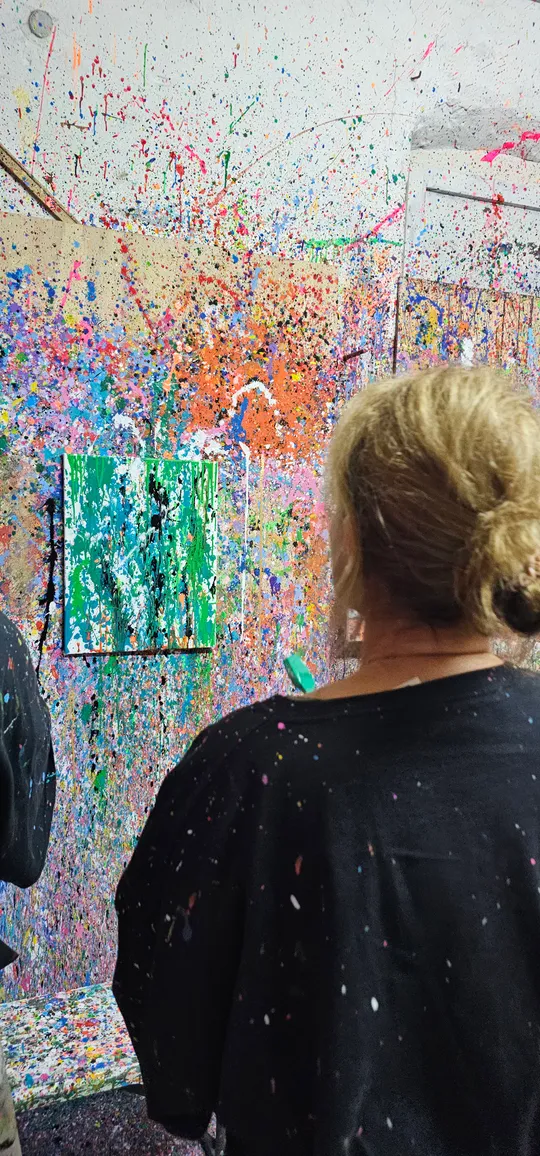 Person betrachtet abstrakte Spritzkunst im Studio.