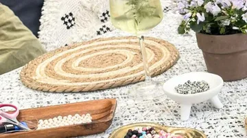 Craft beads on table with drink.
