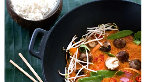 Thai-Curry im schwarzen Topf mit Reis.