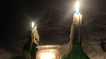 Kerzen in Flaschen auf Schneeplatze.