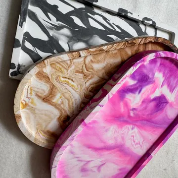 Colorful resin trays on a textured surface.