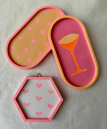 Three colorful trays with polka dots, hearts, glass.