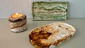Candle, tray, and art in marbled textures.