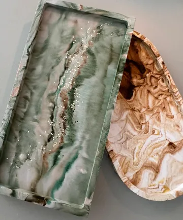 Decorative trays with marble-like patterns and sparkles.
