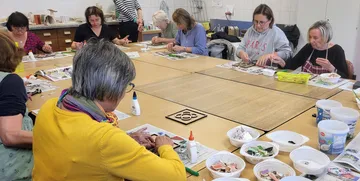 Group crafting at tables with art supplies