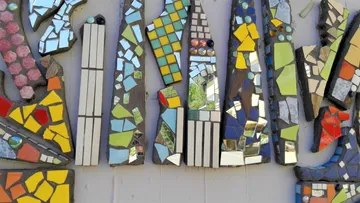 Colorful mosaic tiles on a textured wall.