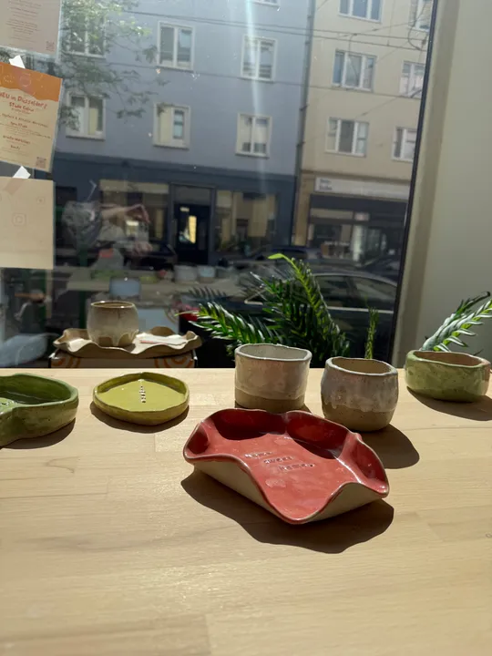 Keramiktassen und Schalen auf Holztisch.
