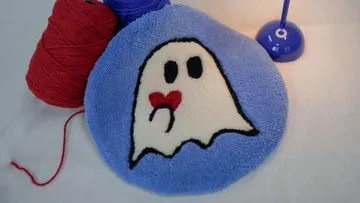 Geist-Kissen auf Tisch mit Garn.