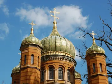 Dome with golden decorations against a blue sky.