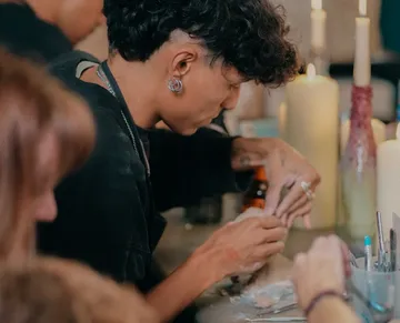 Person crafting at table with candles.