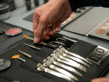 Werkzeuge werden von einer Person aus einer Tasche entnommen.