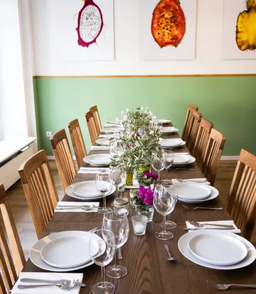 Table set with plates and glasses, artwork above.