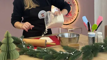 Person gießt Mehl auf Küchentheke.